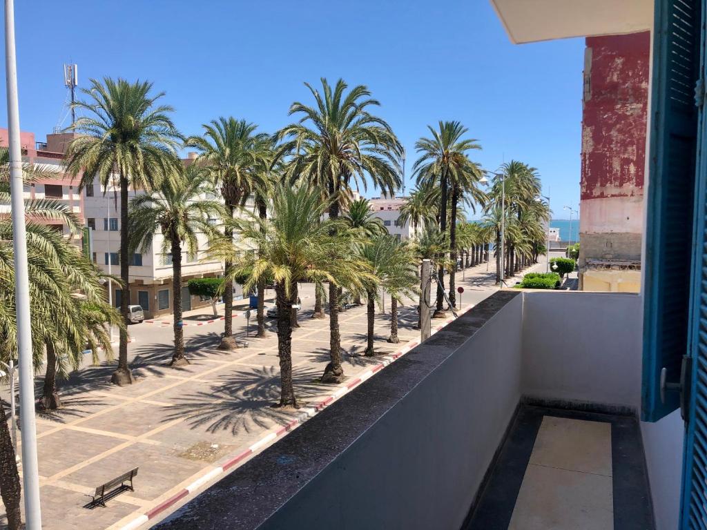 纳祖尔Hotel El Maghreb Al Kabir的从棕榈树建筑的阳台上可欣赏到风景