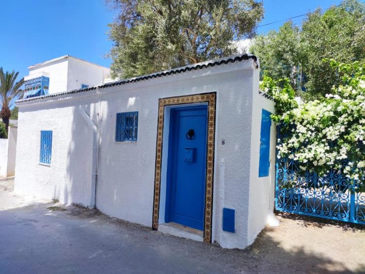 西迪·布·赛义德Maison à Sidi Bou Said的白色的建筑,上面有蓝色的门