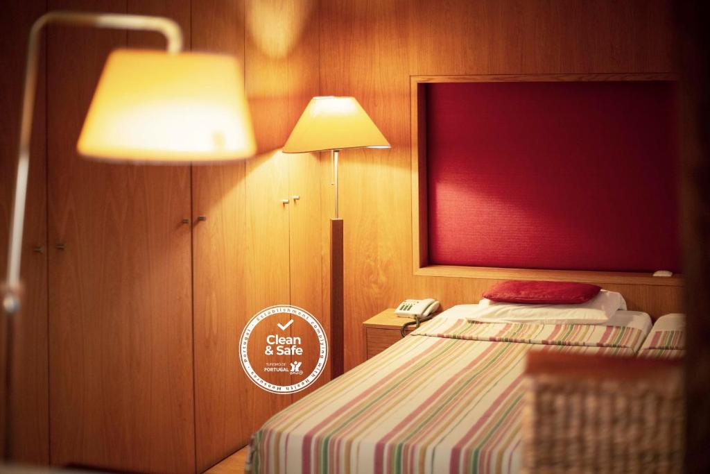 丰沙尔图里斯阿特兰蒂达酒店的一间卧室配有一张带灯和电话的床