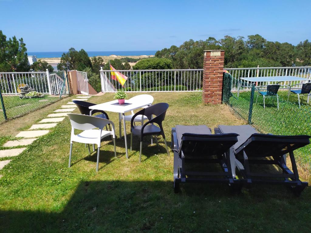 MiengoApartamento con jardin privado junto playa Usil - Mogro的草丛中的一组桌椅