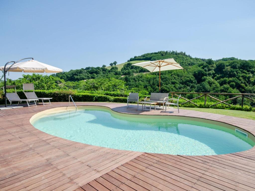 乌尔比诺Belvilla by OYO Villa Angolo Fiorito的一个带桌椅和遮阳伞的游泳池