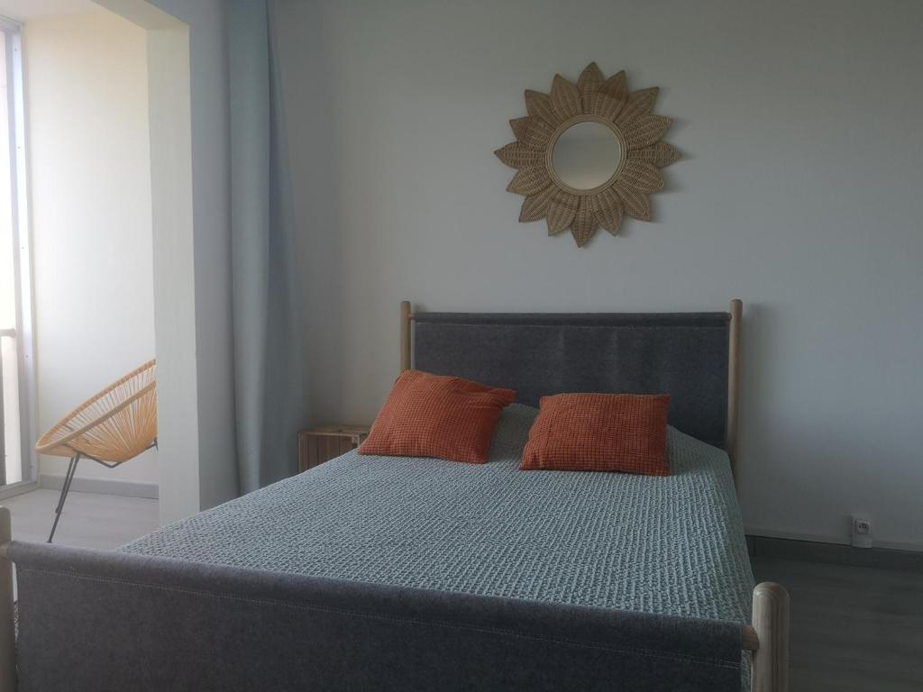勒格罗-迪鲁瓦ESCALE AU GRAU DU ROI的一张带两个橙色枕头和镜子的床