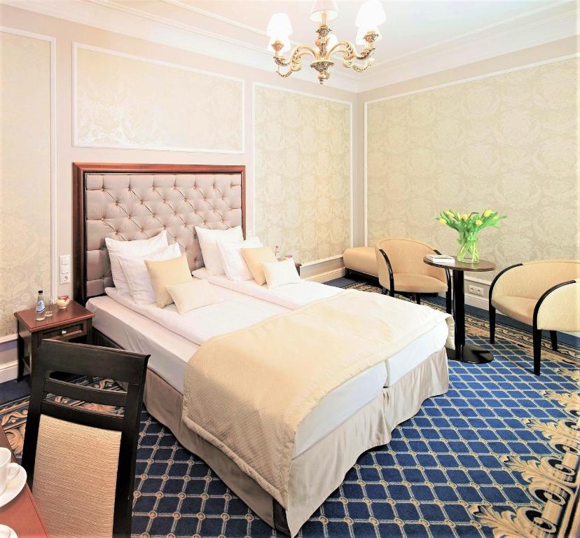 里加格特鲁德瑞克斯韦尔酒店的一间卧室配有一张大床和一张桌子及椅子