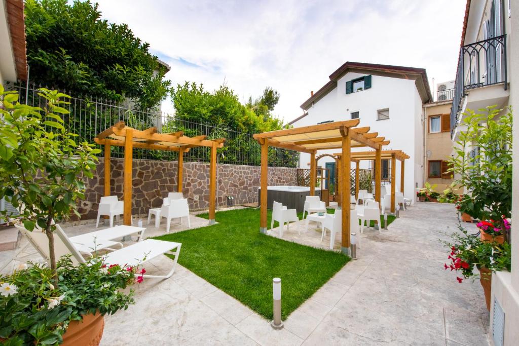 拉维罗拉维罗公寓式酒店的一个带木制凉亭和白色椅子的花园
