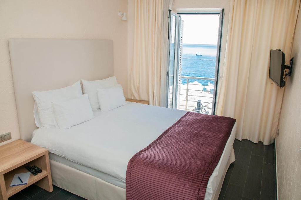布德瓦明星酒店的一间卧室设有一张大床,享有海景