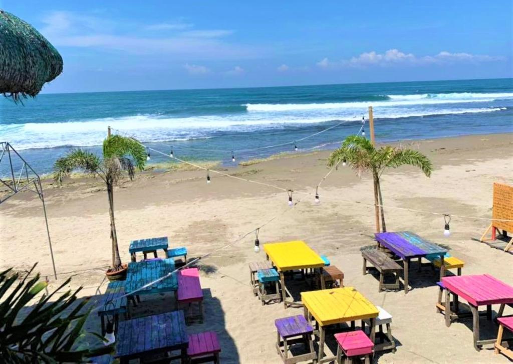 圣胡安Surfer's Point Deck的海滩上摆放着五颜六色的桌椅,大海中