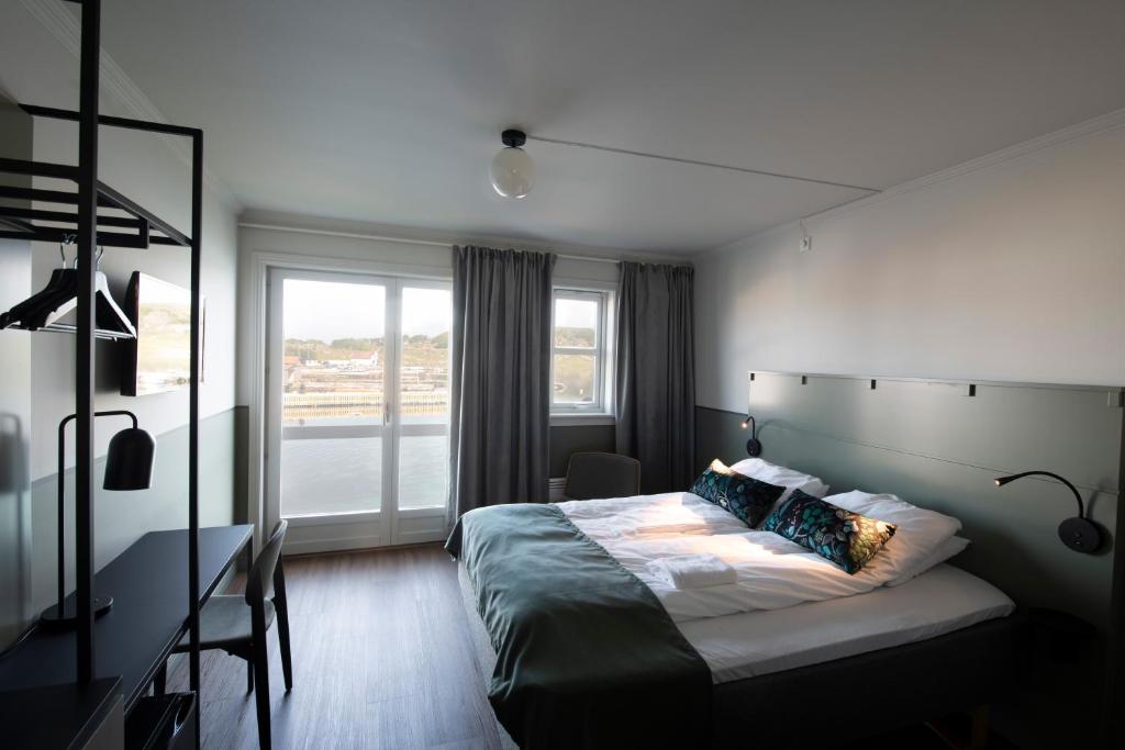 MosterøyUtstein Kloster Hotell的一间卧室设有一张大床和一个窗户。