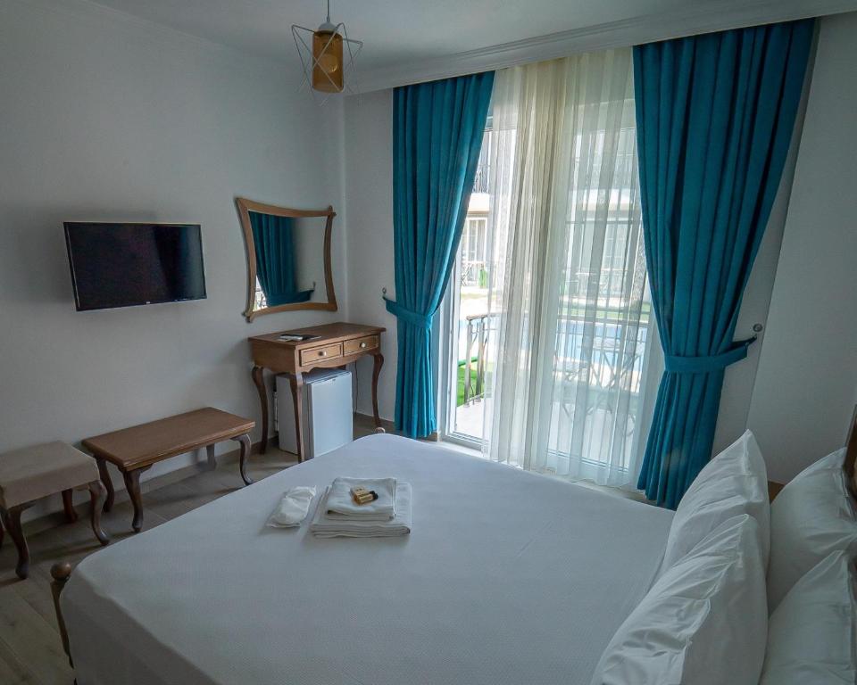 塞利米耶Green Boutique Selimiye的一间卧室配有一张床、一张桌子和一个窗户。