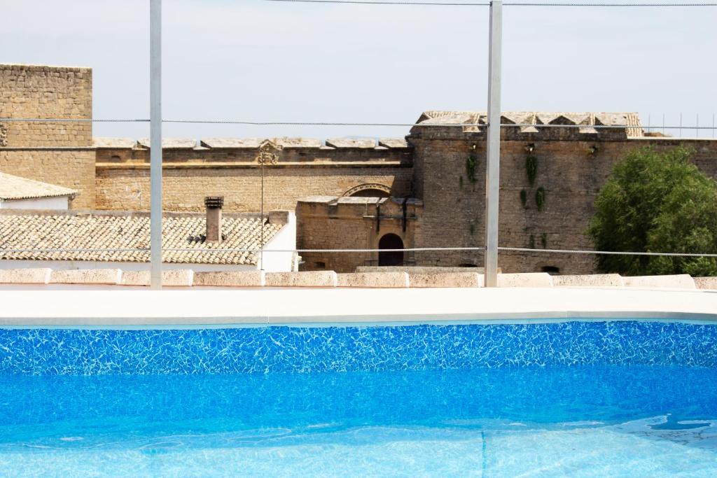 萨比奥特Hotel Rural Molino del Albaicín的一座古老建筑前的蓝色游泳池