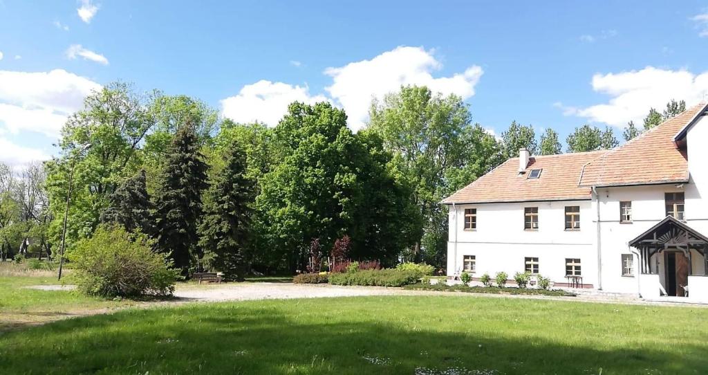 KomorowoDwór Komorowo的一座带草地庭院的大型白色房屋