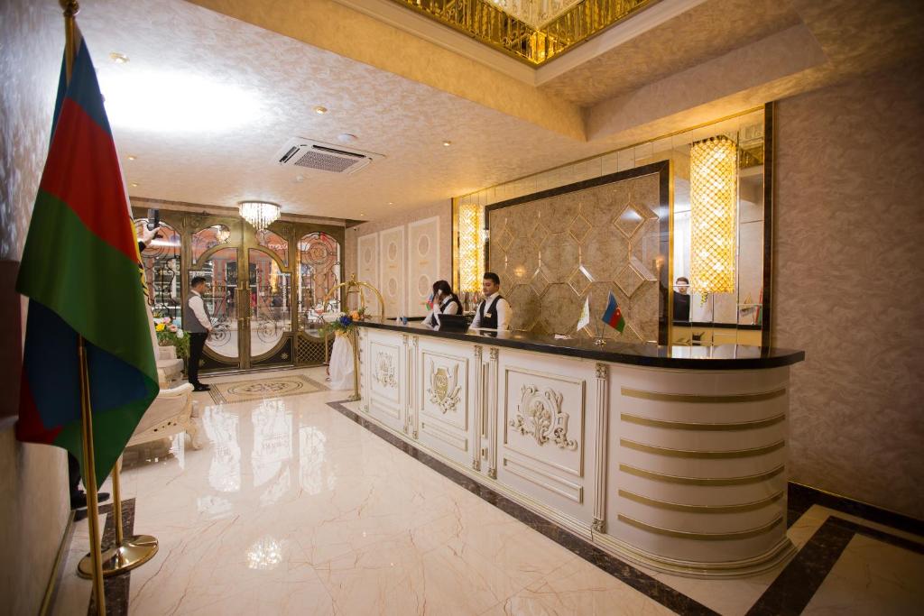 甘贾Baku Hotel Ganja的一家酒店的大堂,两人站在酒吧