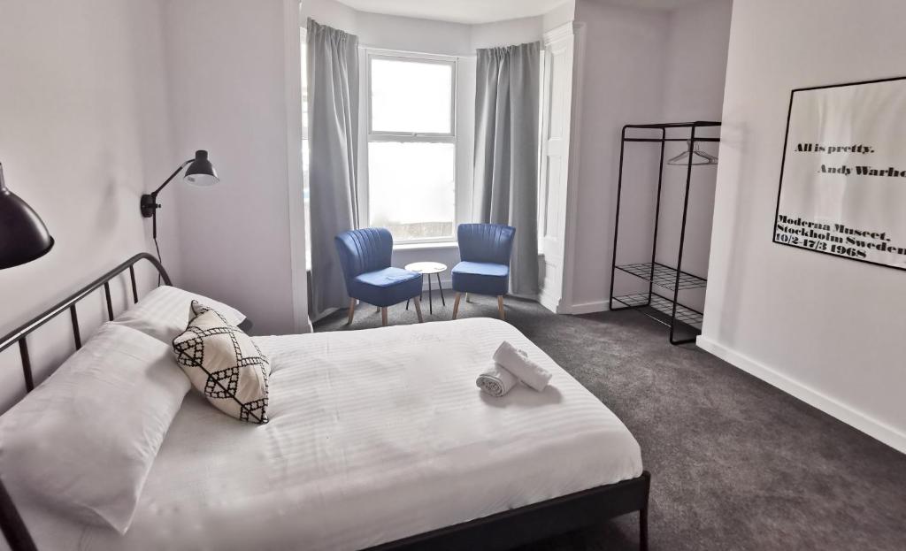 卡迪夫Richmond Apartments by Switchback Stays的卧室配有床、椅子和窗户。