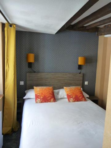 圣马洛马洛港口酒店的卧室配有白色床和2个橙色枕头