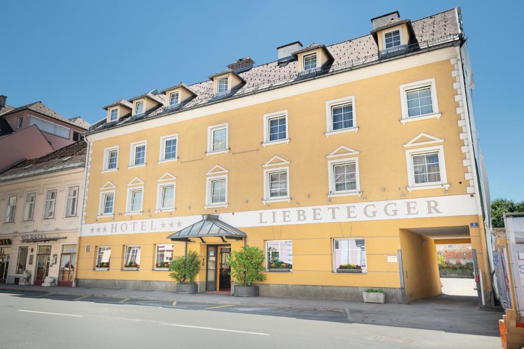 克拉根福Hotel Liebetegger-Klagenfurt的一座黄色的大建筑,有救生员字眼