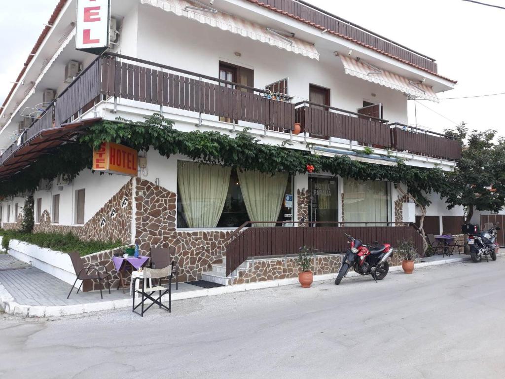 内亚卡瓦里Hotel Paralia的停在前面的一座带摩托车的建筑