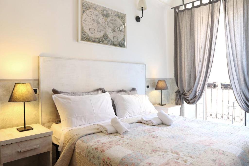 罗马Guest House Relais Indipendenza的一间卧室配有一张带两盏灯的床和一扇窗户。