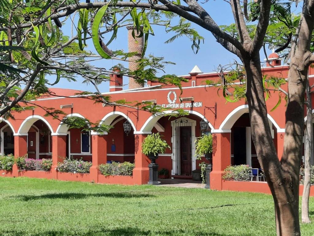 JantetelcoHacienda Santa Clara, Morelos, Tenango, Jantetelco的一座橘色的建筑,前面有一棵树