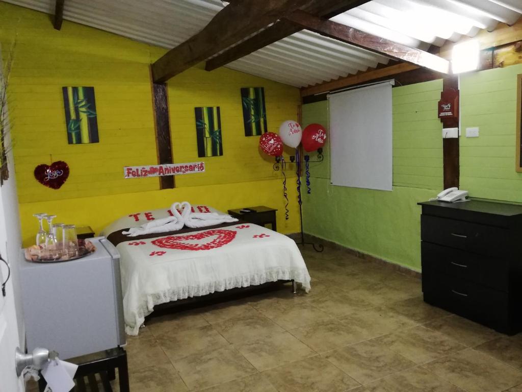 菲兰迪亚Hotel Campestre El Refugio de Balsora的一间卧室设有一张红色和绿色的墙壁。