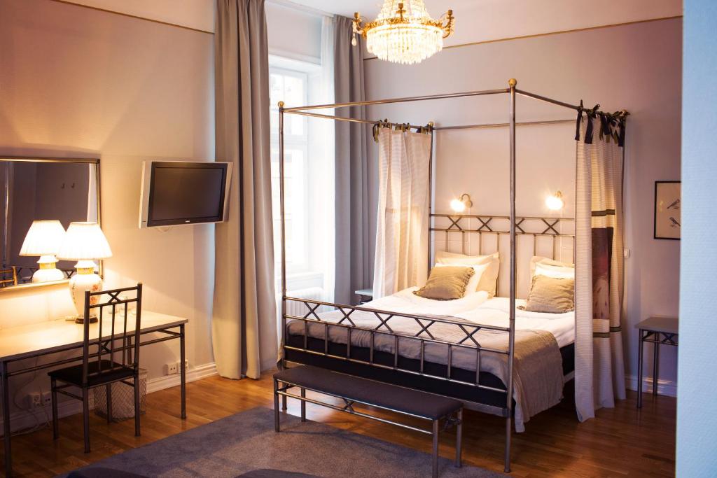 乌普萨拉霍恩格兰德酒店的一间卧室配有四柱床和一张书桌