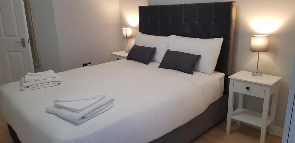 韦克斯福德Apartment in the heart of wexford town的卧室配有带毛巾的大型白色床
