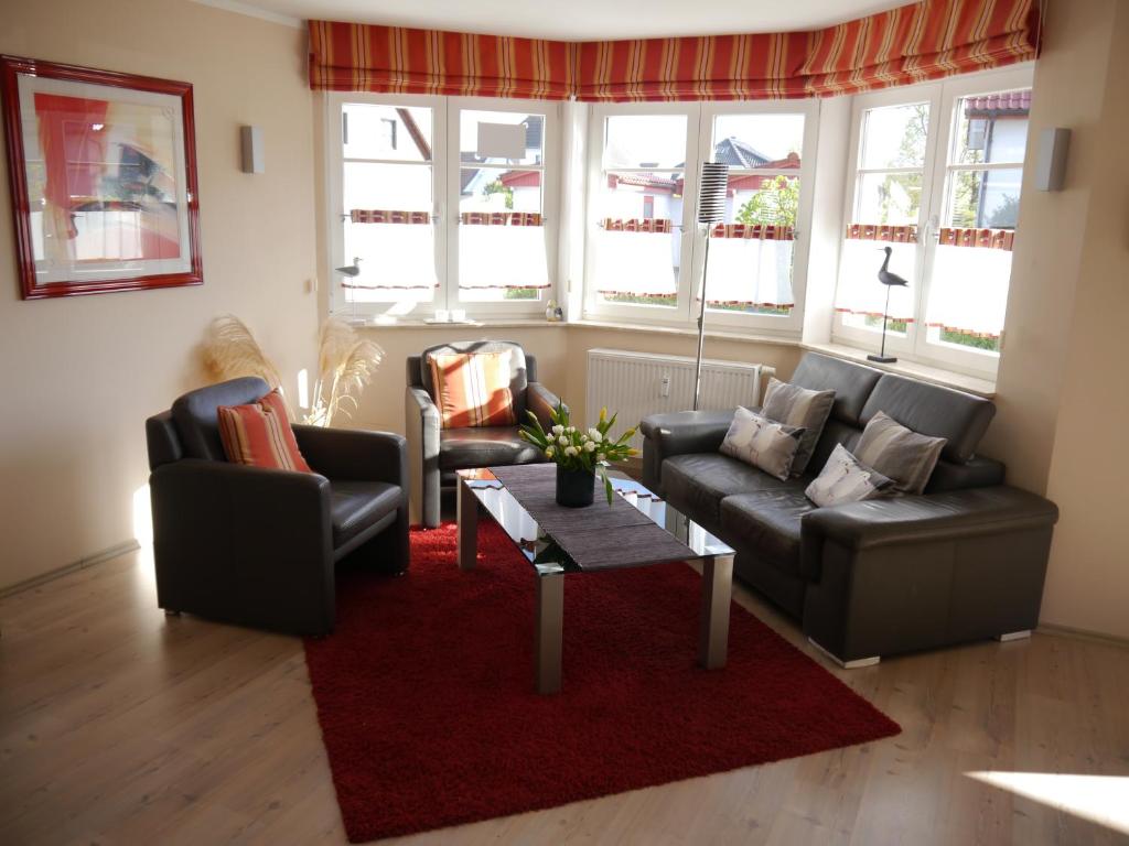 青斯特Sünnenkringel 68 Appartement 1的客厅配有两张沙发和红色地毯
