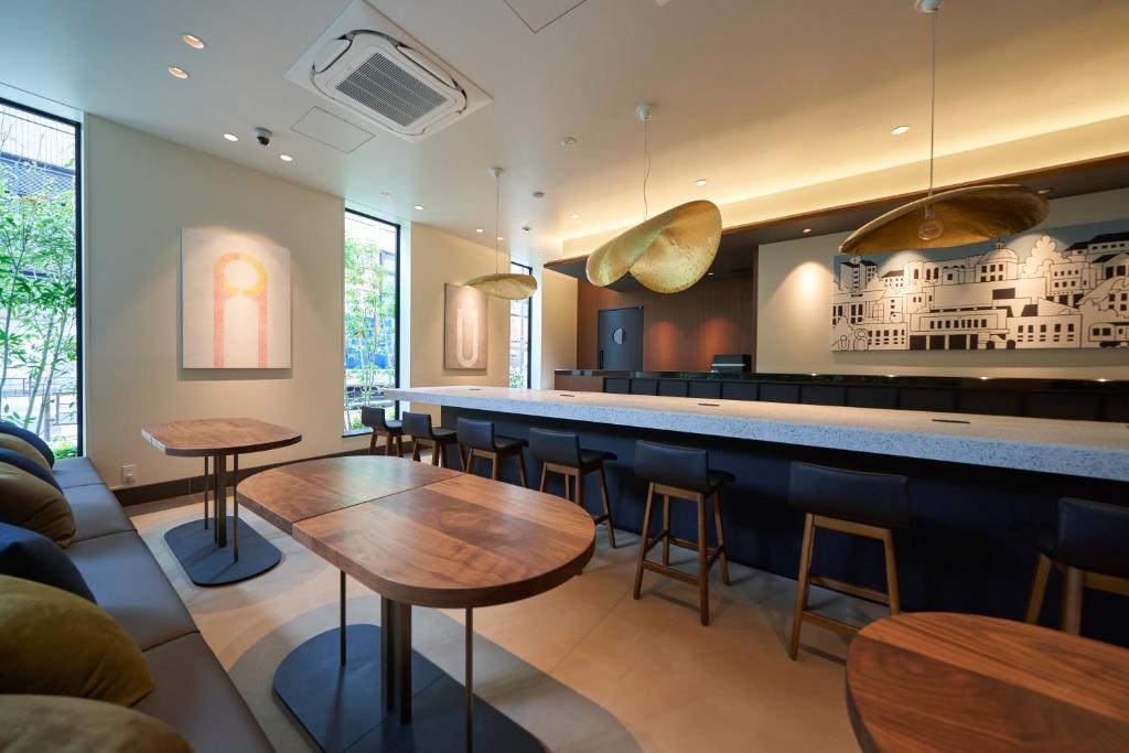 东京Hotel Resol Ueno的餐厅内的酒吧配有桌椅