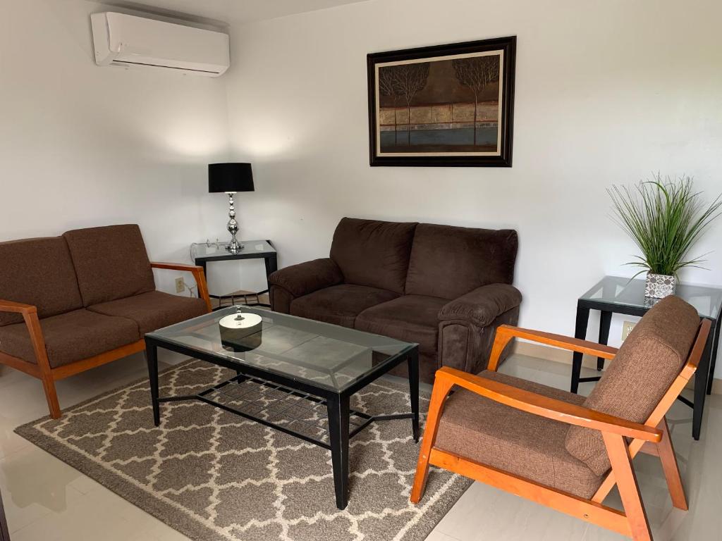 HagatnaPrivate Chalan Pago Apartment的客厅配有沙发和桌椅