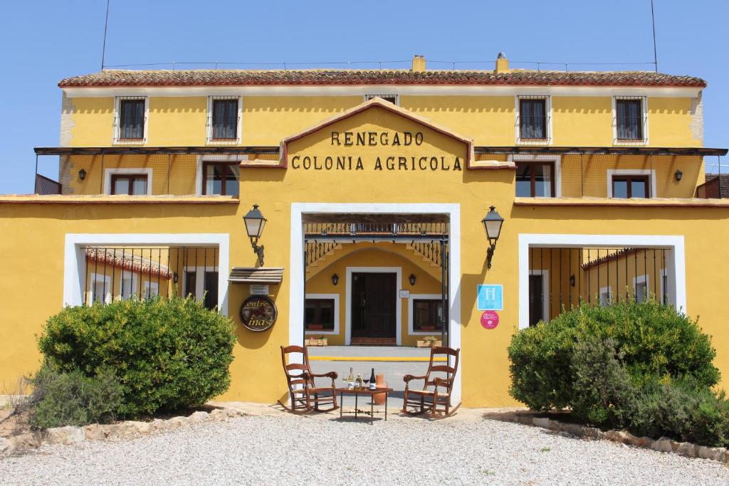 Caudete de las FuentesHotel rural Entreviñas的前面有一张桌子的黄色建筑