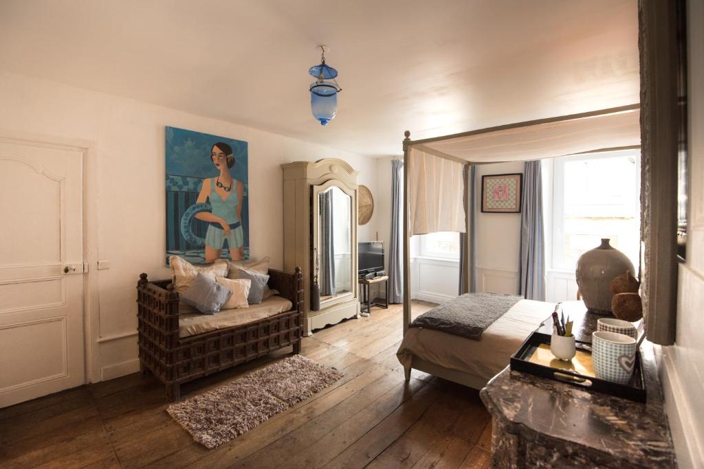 蓬蒂维莱斯尚布勒斯鲁尔梅尔酒店的一间卧室配有一张床、一张沙发和一面镜子