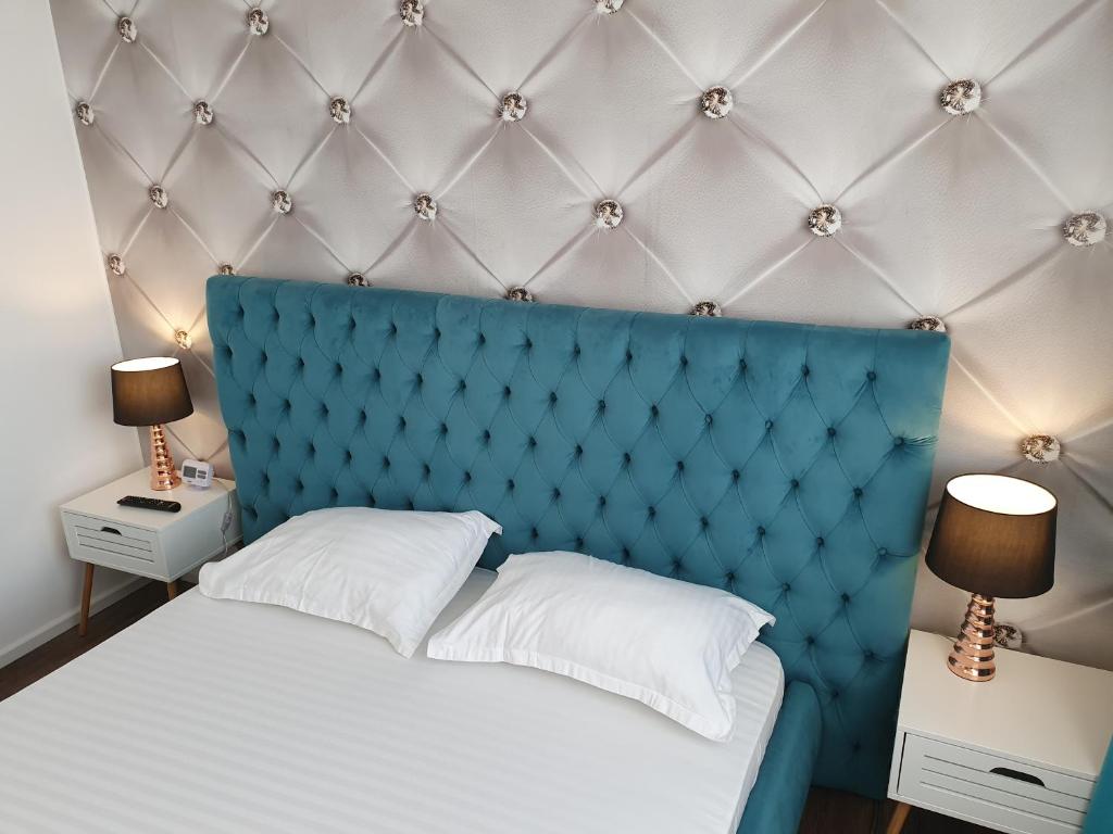 塔古玖ARISTOCRAT CENTRAL的一张带蓝色床头板和2个床头柜的床