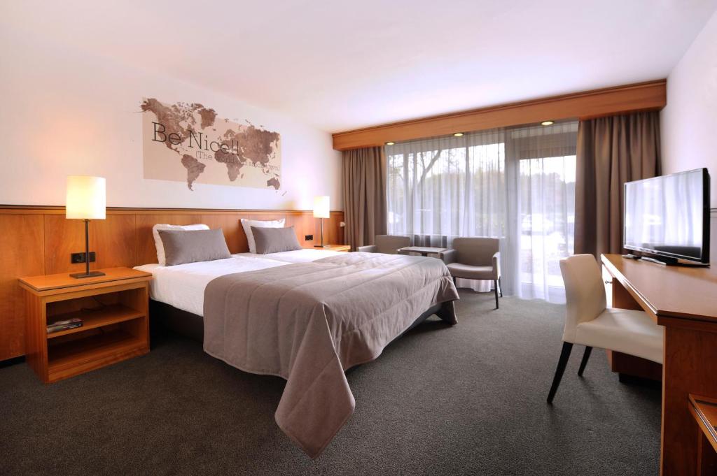 于尔蒙德凡德瓦克酒店的配有一张床和一台平面电视的酒店客房