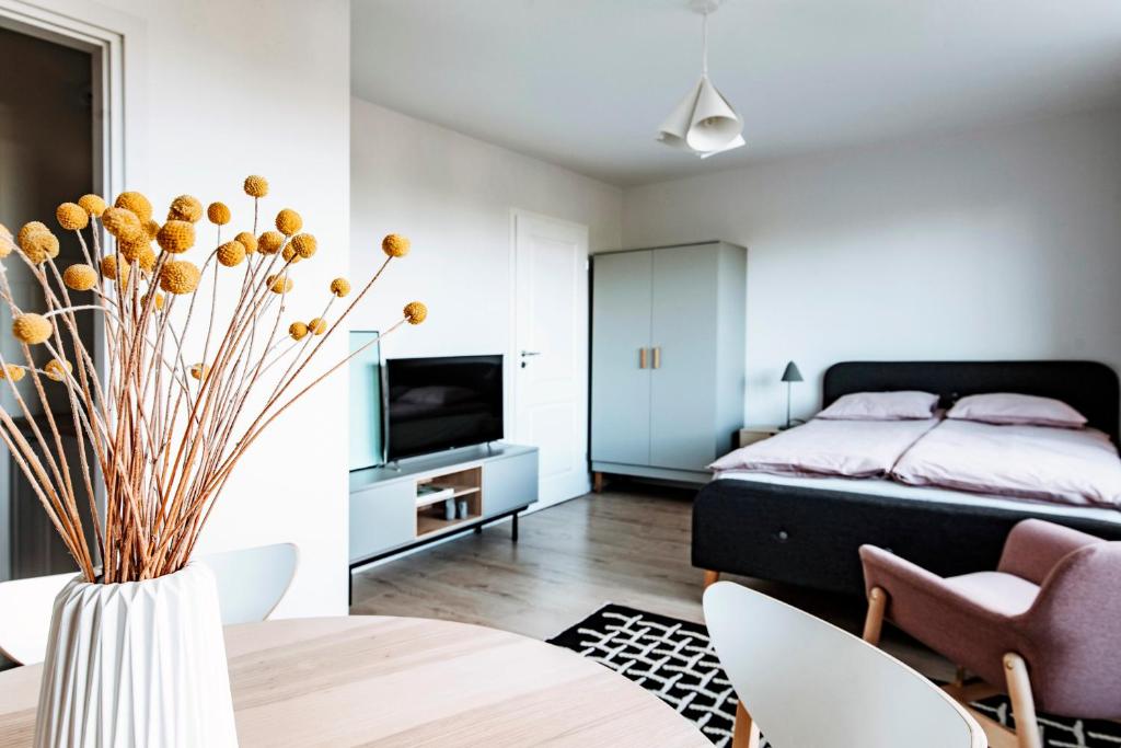 格丁尼亚Gdynia Square Apartment的一间卧室配有床和花瓶