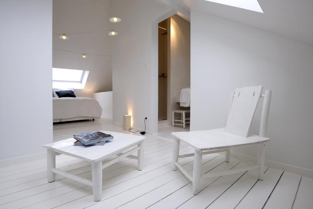 布鲁塞尔La Maison Haute guesthouse的白色的客厅配有椅子和桌子