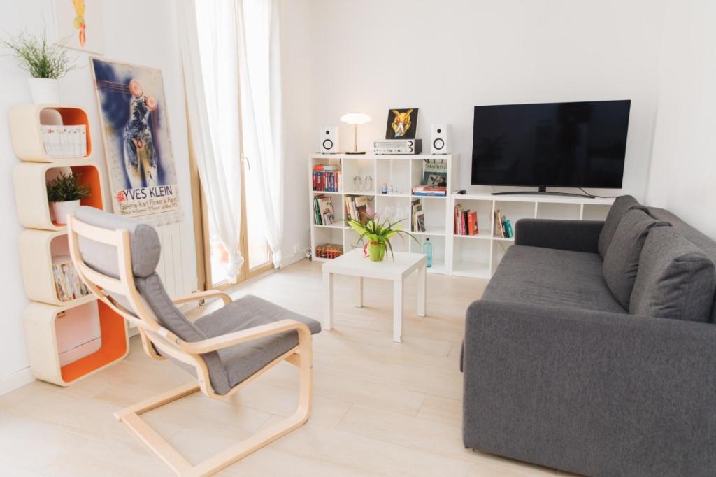 塔拉戈纳LA SURFERA APARTMENT的客厅配有沙发、椅子和电视