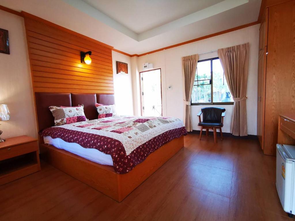 坤敬RS Phong Riverside Resort的一间卧室配有一张大床和一把椅子