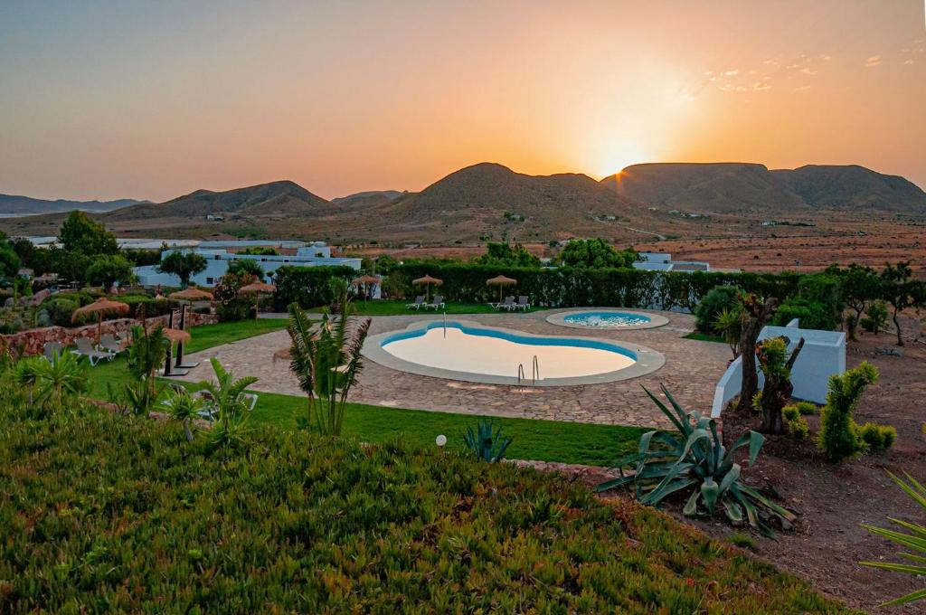 厄尔·波索·德·洛斯·弗莱尔Finca Maltes San José的享有带游泳池和日落的度假村景色