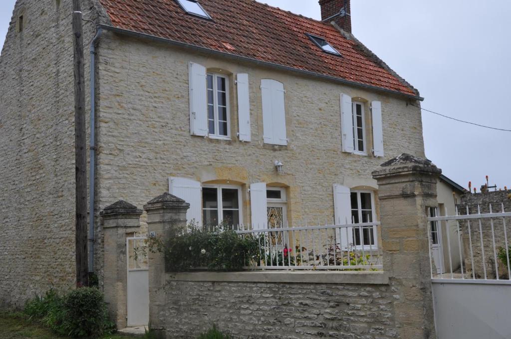 Longues-sur-MerLe petit clos du Bessin的白色围栏的旧砖屋