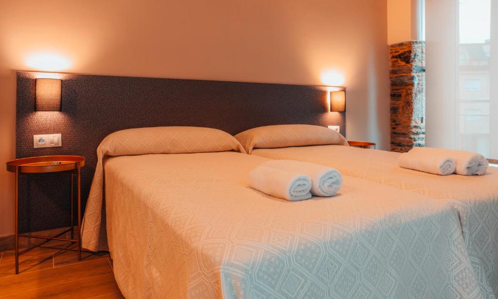 BaleiraPensión A Marronda的一间卧室配有一张大床和两条毛巾