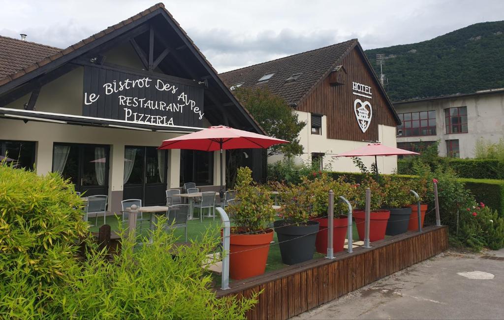 盖拉德The Originals Annemasse Sud - Porte de Genève的一间餐厅,前面有雨伞和盆栽植物