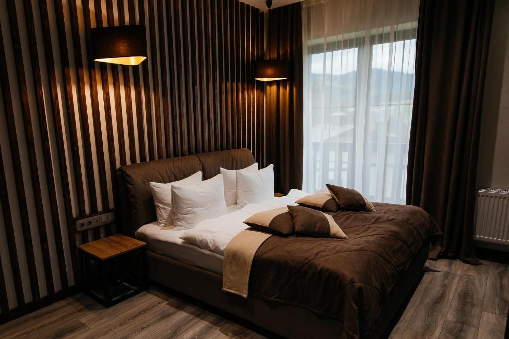 布克维CHALET NEBO的卧室配有带枕头的床铺和窗户。