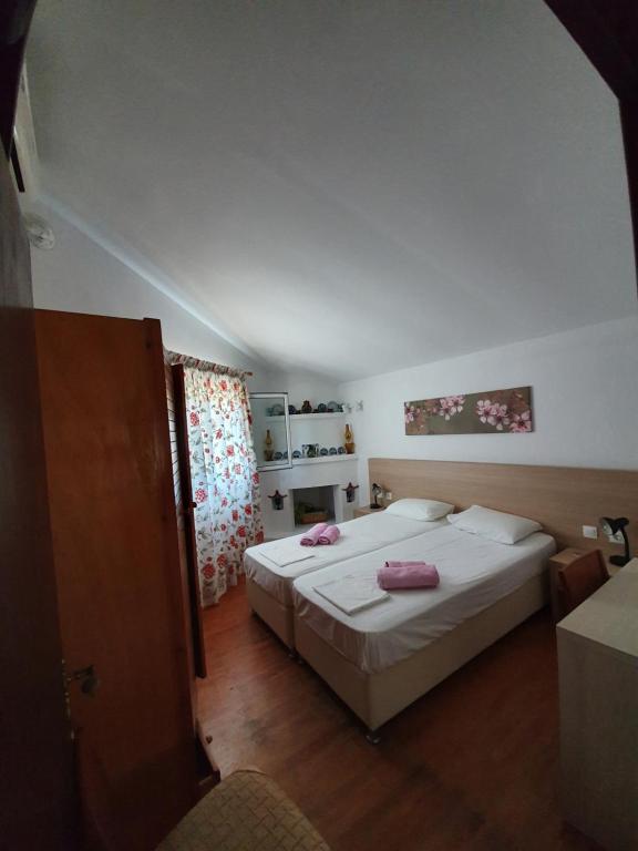 考考纳里斯Dionisos Studios and Apts Skiathos的一间卧室配有两张床,上面有粉红色的毛巾