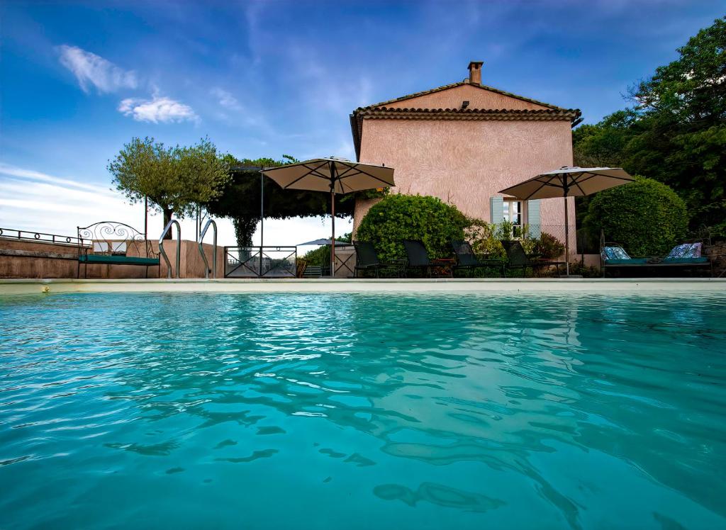 阿普特Chez Manon的一座带遮阳伞的房屋前的游泳池