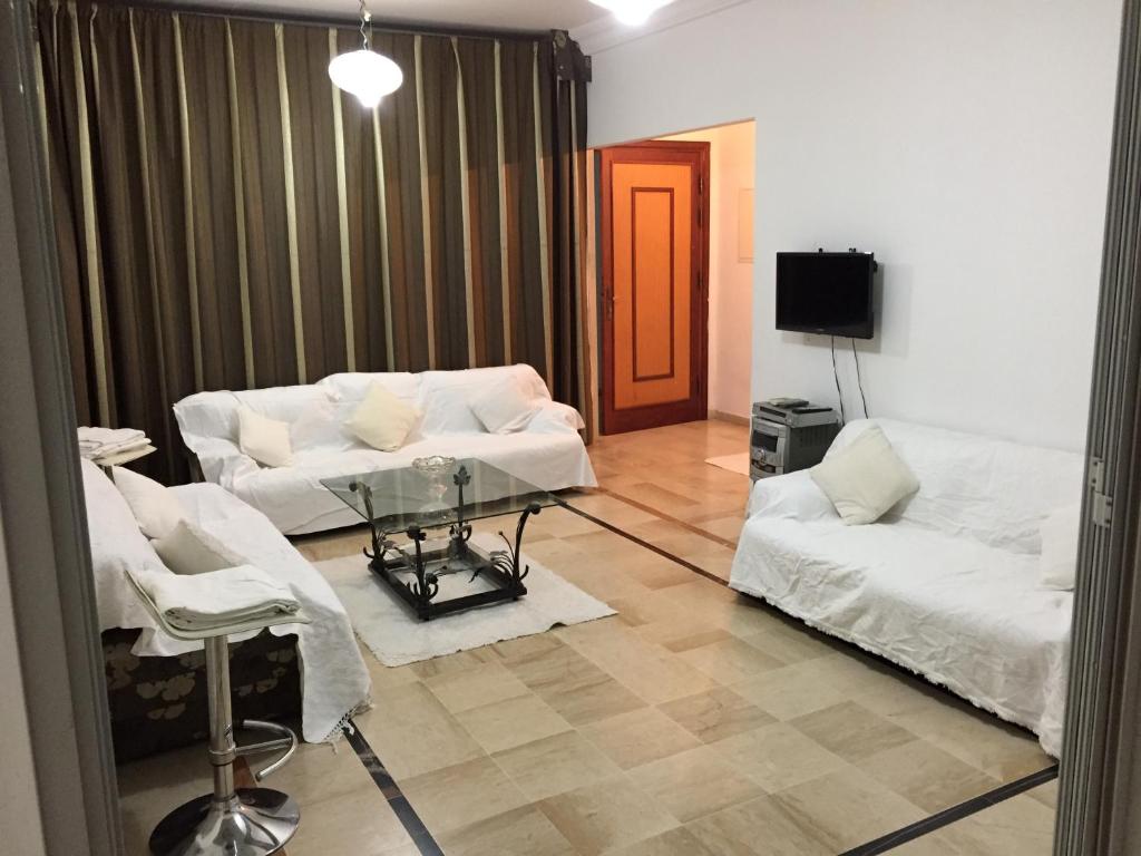 Boumhel El BassatineBelaire host appartment的客厅配有2张白色沙发和1台电视