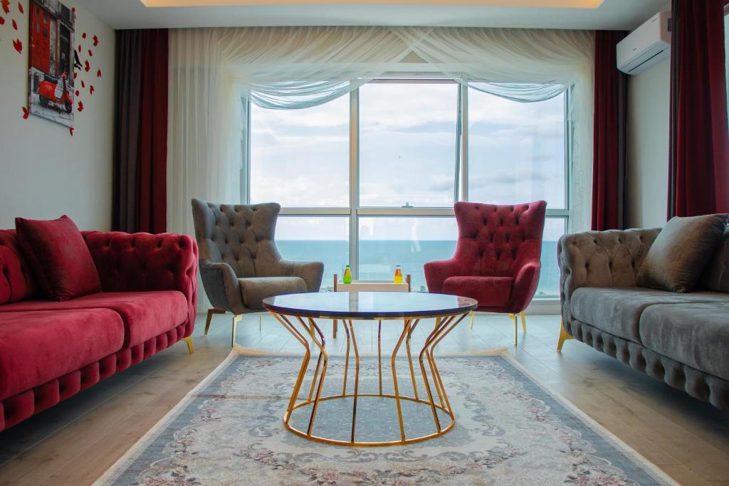特拉布宗ELEGANT BLUE SUİTES的客厅配有红色家具和大窗户