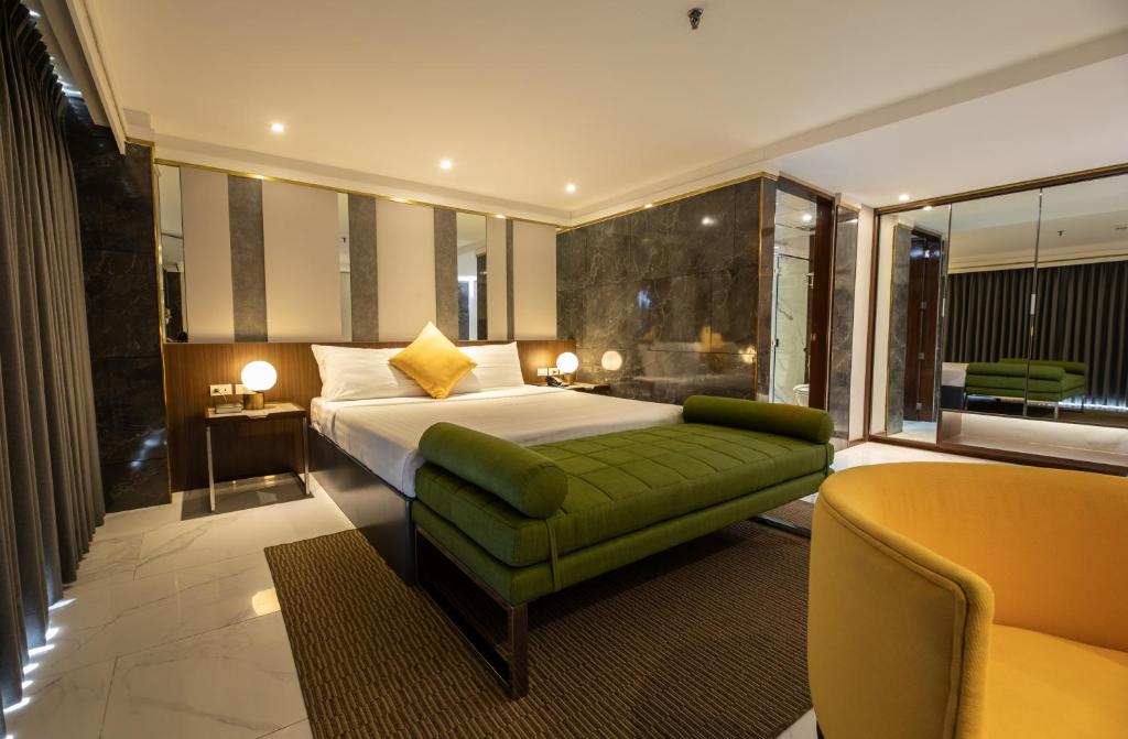 达古潘星光广场酒店的酒店客房,设有一张床铺和一张绿色沙发