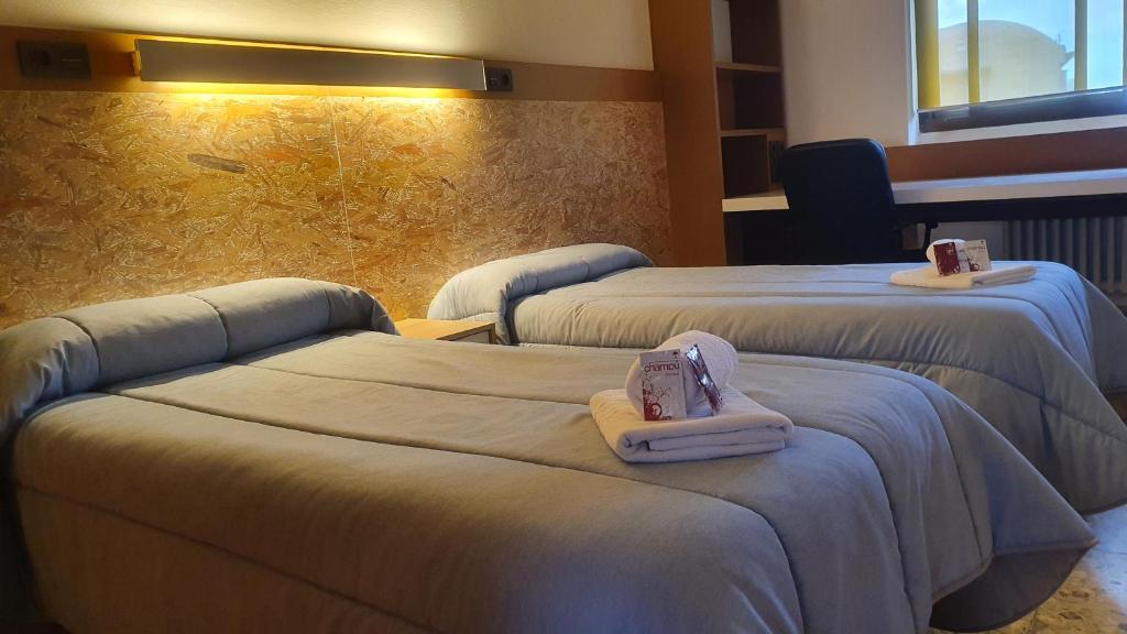 莱昂Albergue Peregrinos San Francisco de Asis的酒店客房,配有两张带毛巾的床