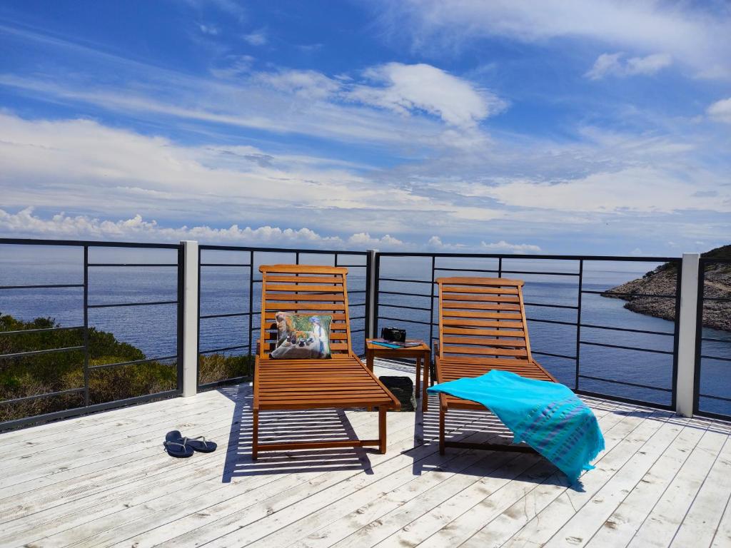 木洛希尼Living Point Mobile Homes的两把椅子坐在俯瞰着水面的甲板上