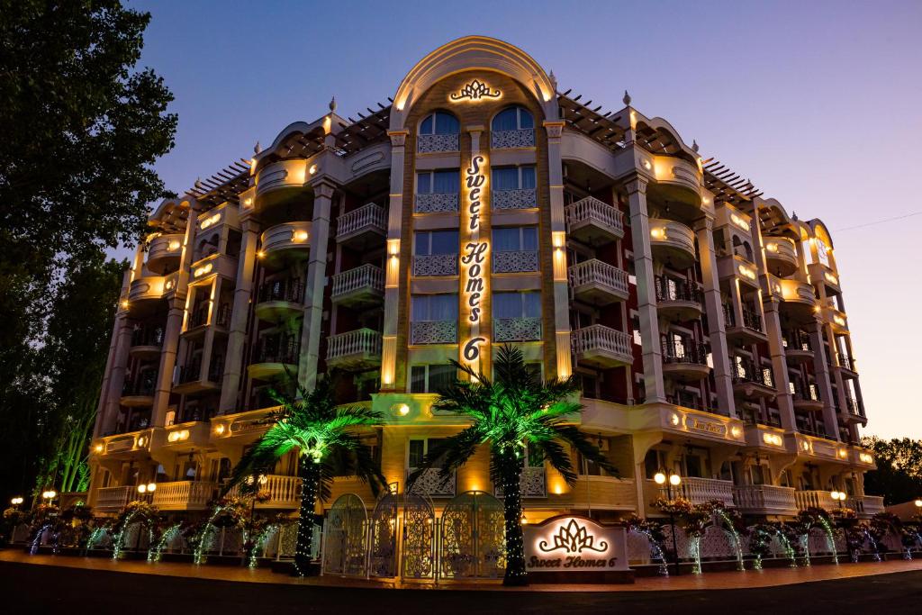阳光海滩Sweet Homes 6 Apartments的一座棕榈树环绕的大建筑