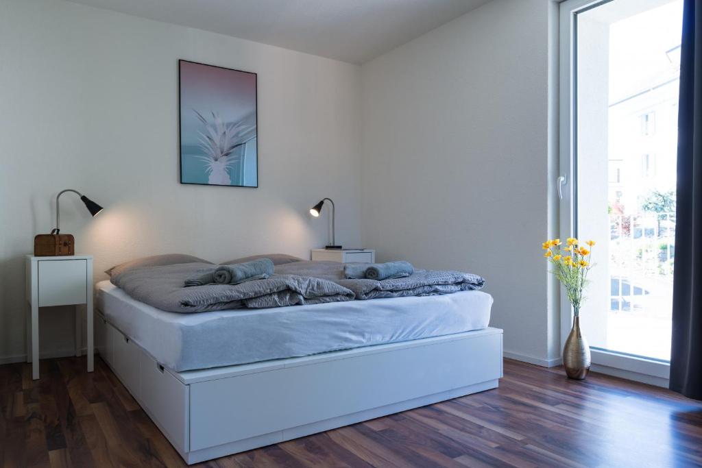 苏黎世HITrental Wiedikon Apartments的白色卧室配有蓝色床单