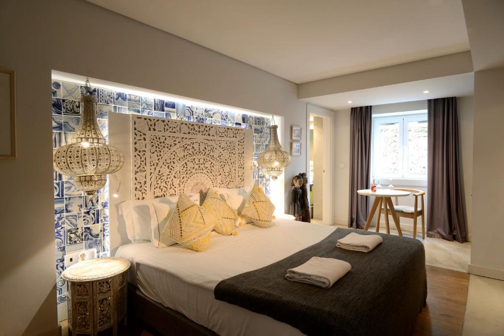 里斯本达尔马老城套房公寓的一间卧室配有一张带黄色枕头的大床